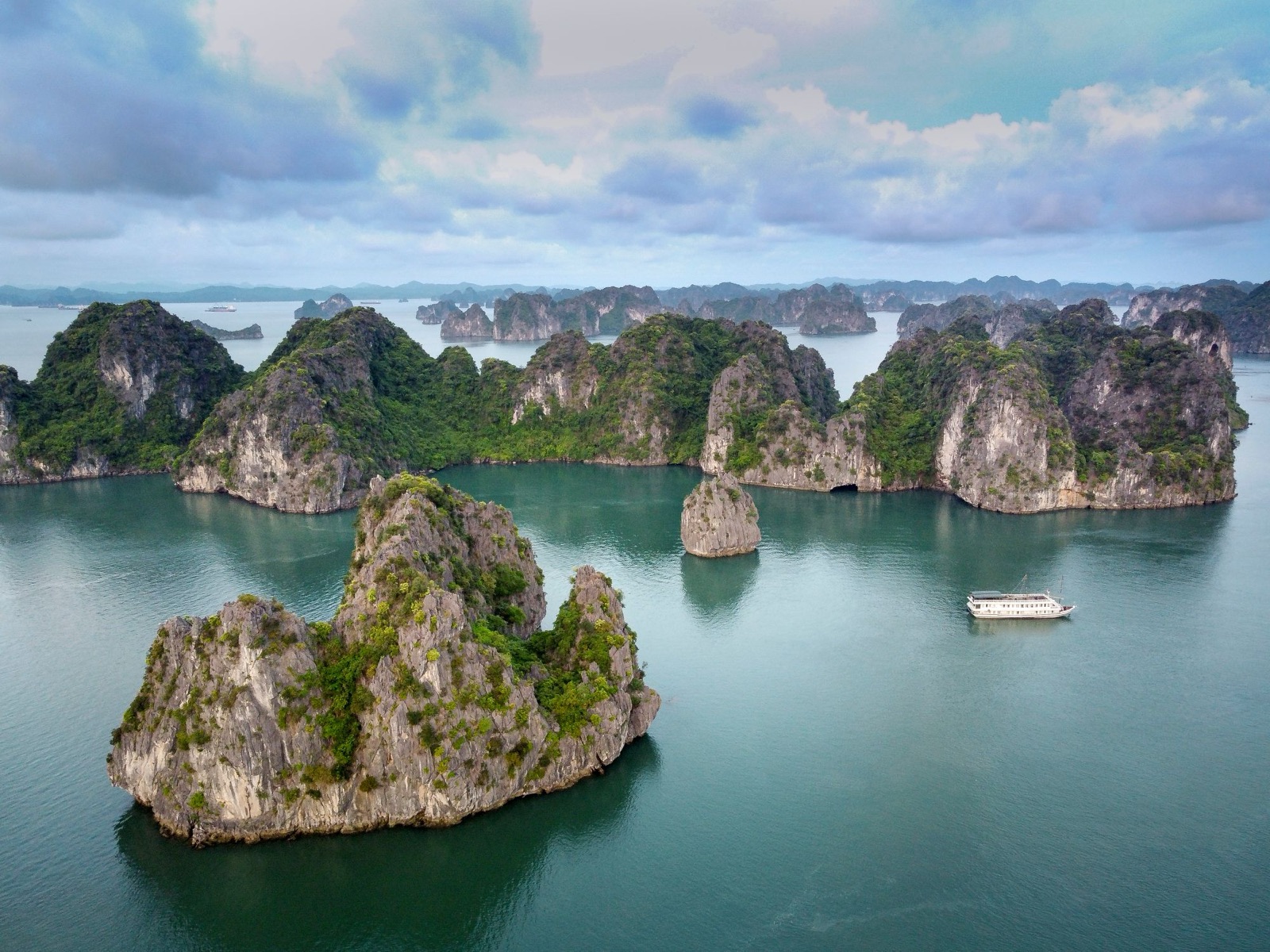 Islas de piedra caliza en el agua turquesa de la bahía de Hạ Long